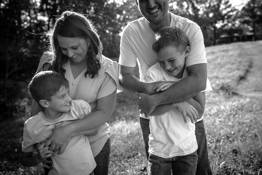 Black and white collage of tender family moments showing parents playing and bonding with children outdoors.