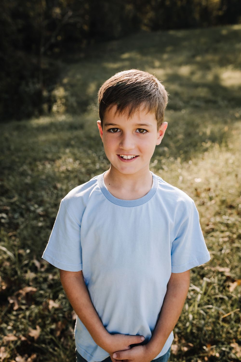 A sequence of outdoor portraits showing a child in a light blue t-shirt with changing expressions in natural lighting.