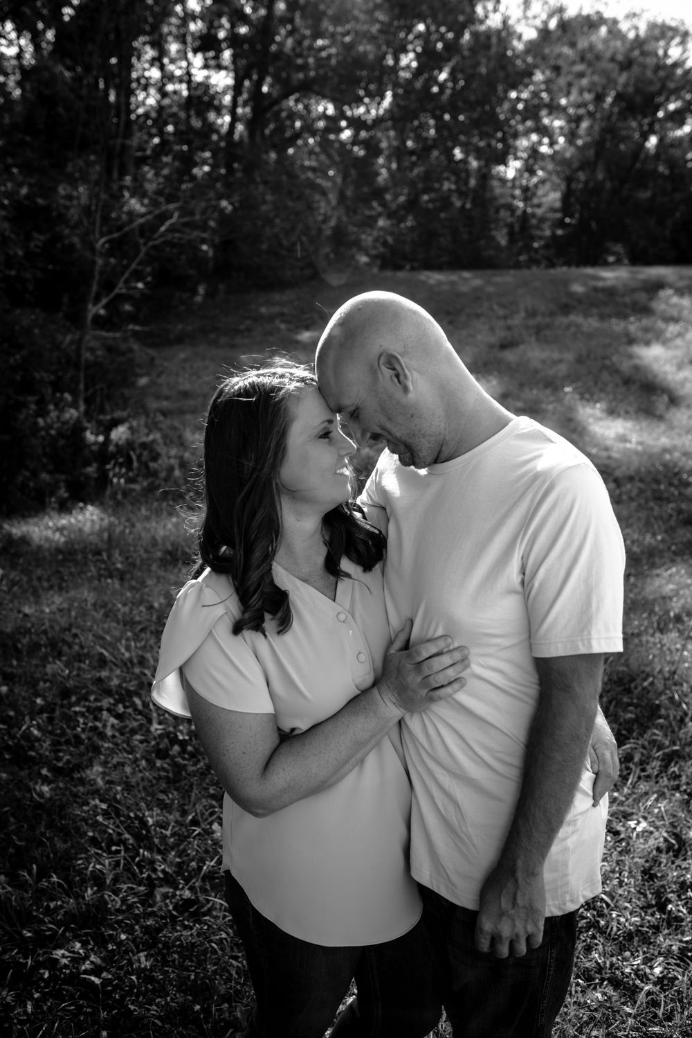 Couple sharing intimate moments in black and white photography outdoors during golden hour.