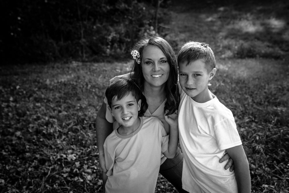 A collection of black and white family portraits showing tender moments between loved ones in a natural setting.