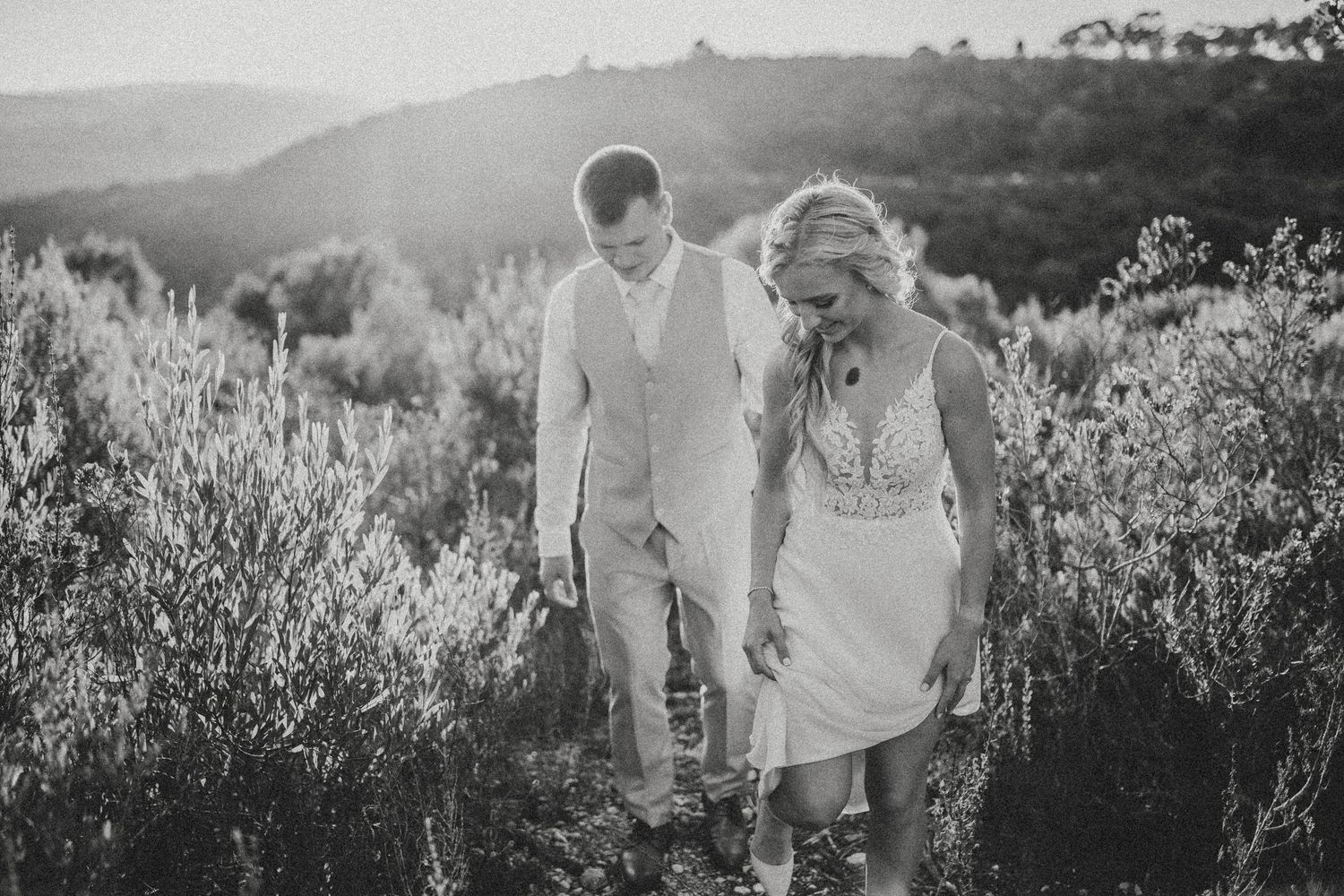A couple embracing in a scenic mountain landscape at sunset.