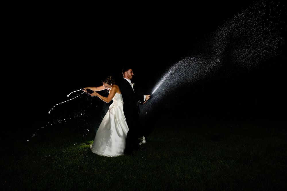 Silhouette of dancers performing an elegant dip move outdoors at night with dramatic backlit effect.