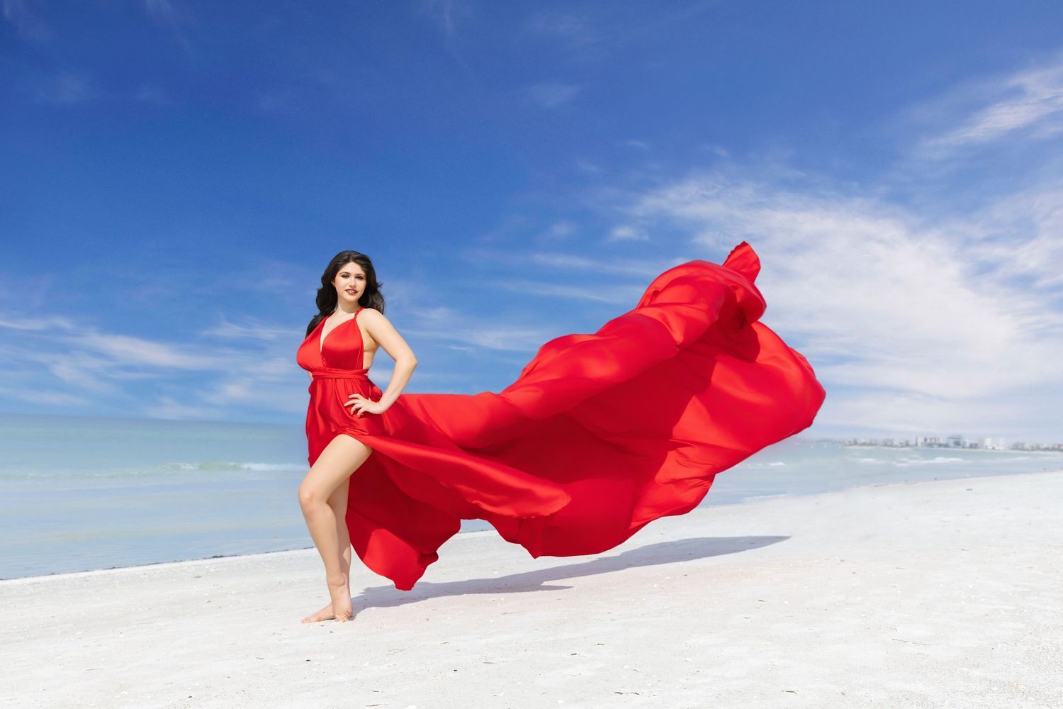 A flowing red fabric billows gracefully against a bright blue sky and white sand beach in a series of connected photos.