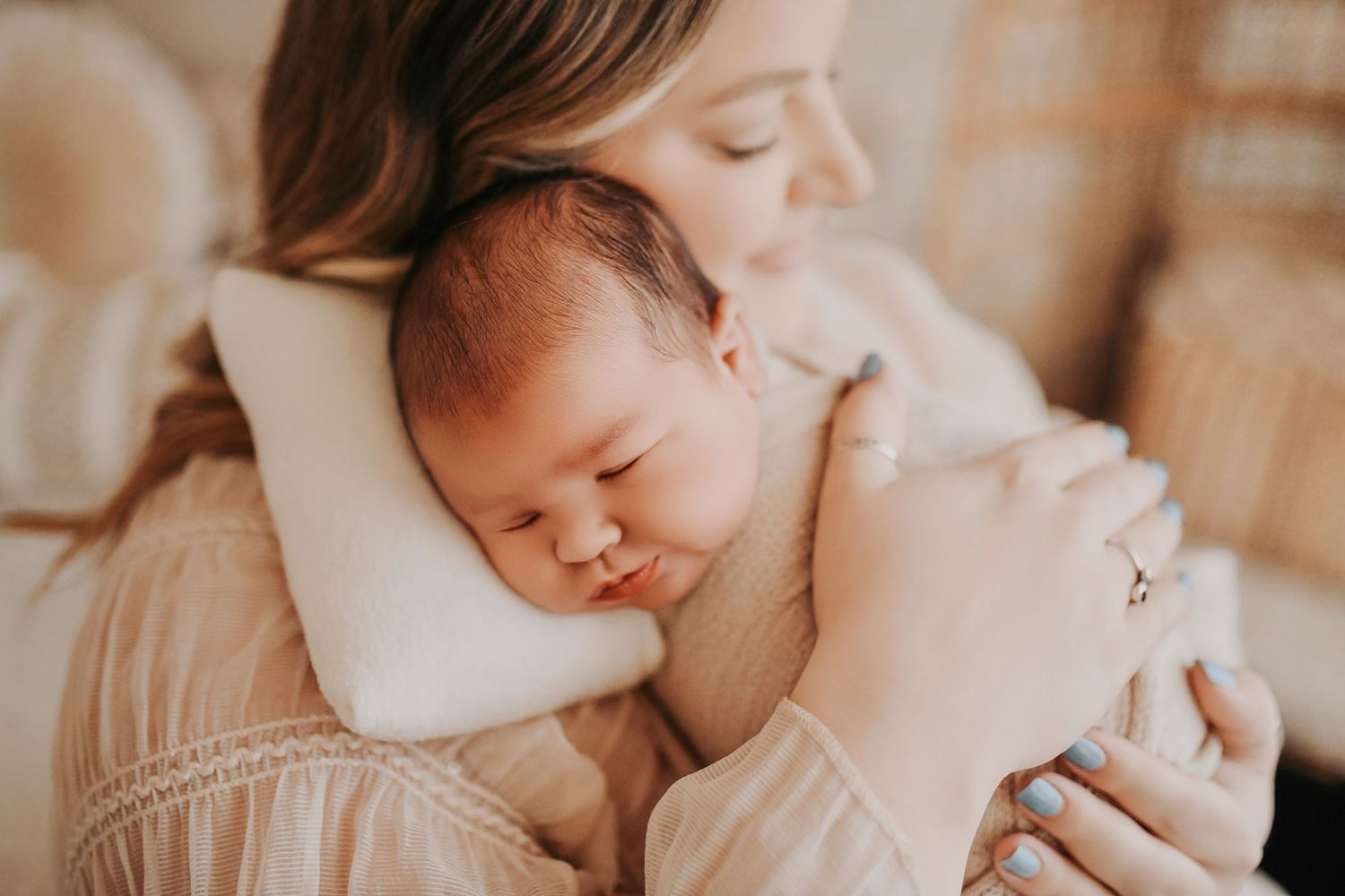 Tender lifestyle newborn image of mom holding baby close