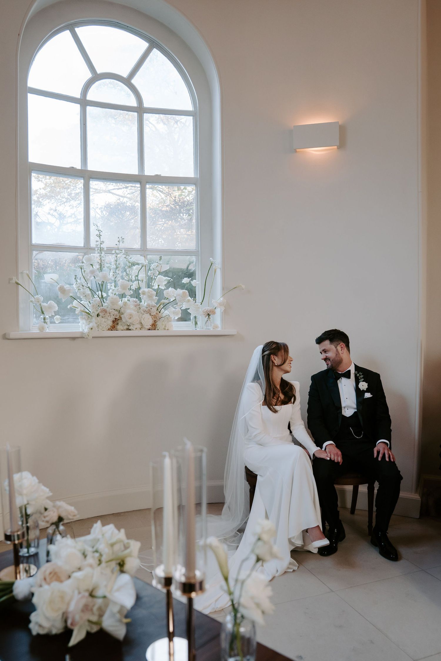 bride and groom sat talking at the front of the ceremony at Iscoyd park
