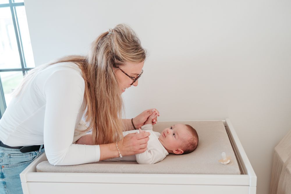 Melissa Stuer Photography Moederschapsfotograaf Moerbeke Oost-Vlaanderen kraamreportage nieuw leven newborn Mama die luier verschoont baby