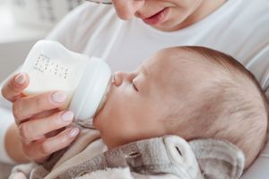 Melissa Stuer Photography Moederschapsfotograaf Moerbeke Oost-Vlaanderen kraamreportage nieuw leven newborn mama en zoon flesje knuffel kus