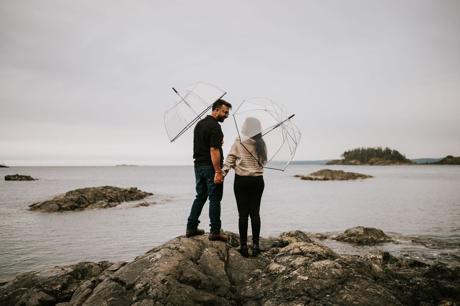 Neck Point Park, Nanaimo, Vancouver Island Engagement Photographer Photoshoot of couple holding hands and umbrellas in rain