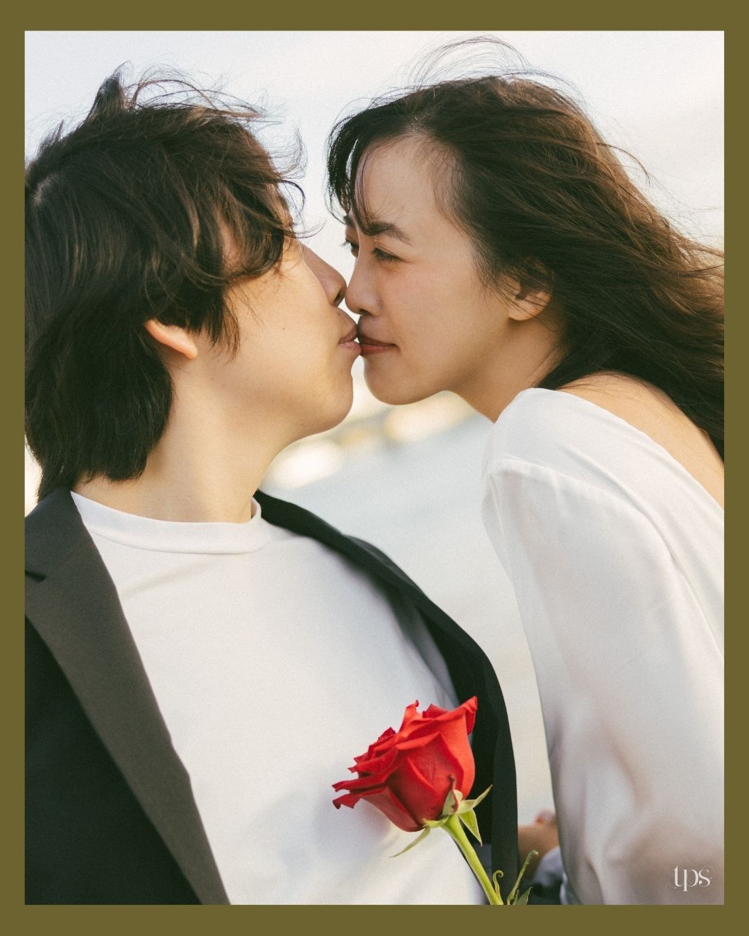 Romantic couple in white sharing tender moments with a red rose, beautifully captured by a professional wedding photographer in Mumbai