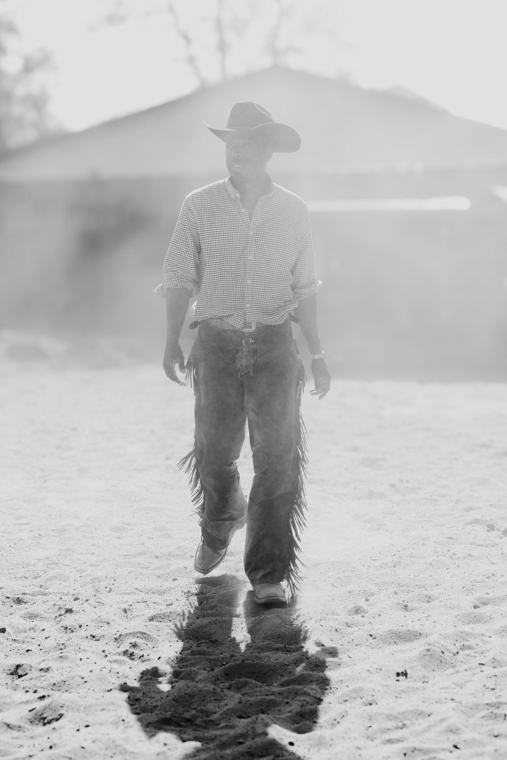 A black and white sequence of a cowboy walking through dusty terrain, creating a misty atmospheric effect.