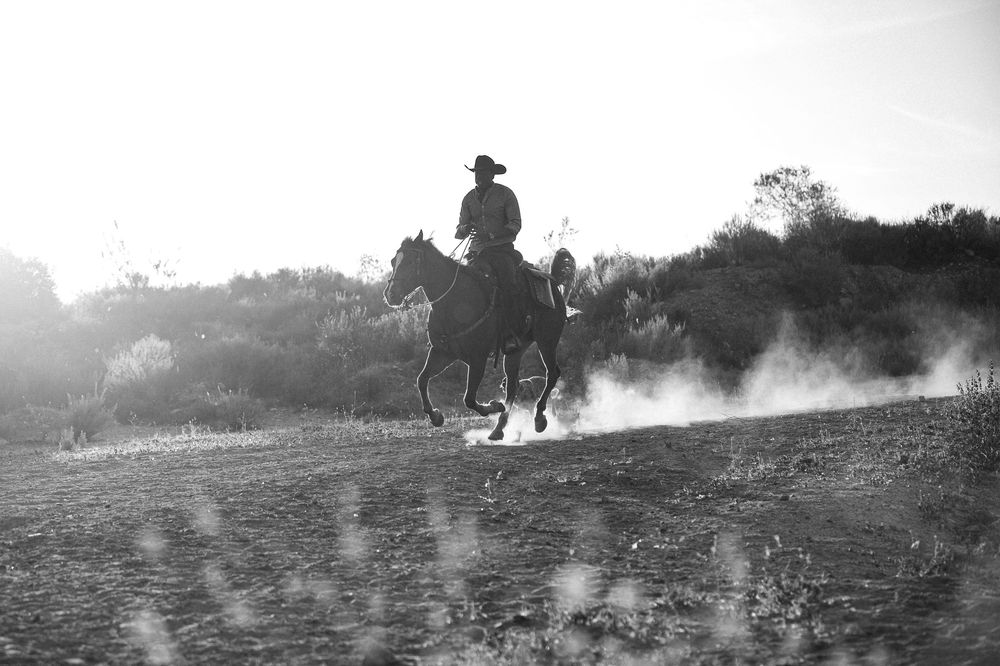 Silhouettes of soldiers running through a smoky battlefield during military combat operations.