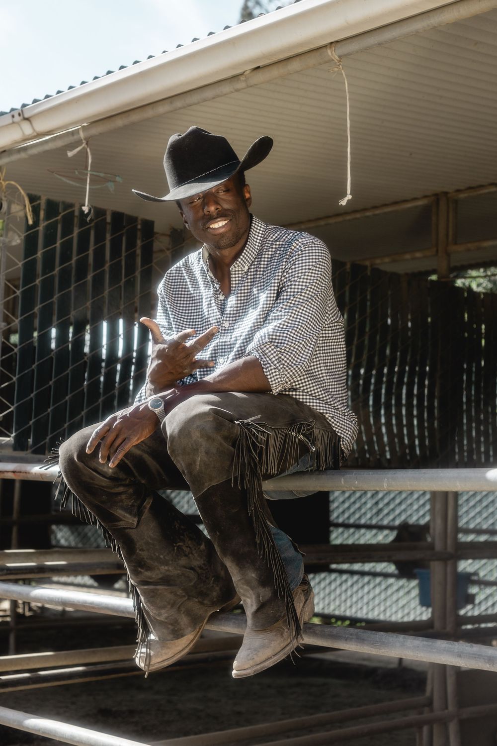 Person sitting on a wooden porch in casual attire with dramatic lighting and shadows.