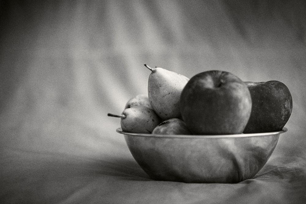 A series of black and white still life photographs showing pears arranged in different compositions and lighting conditions.