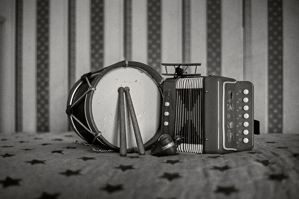 Black and white photo of vintage film reels and editing equipment arranged in a cinematic composition.