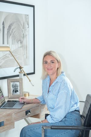 Modern home office setup with laptop and wooden desk against white walls.