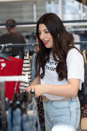 Woman in casual denim and white top shown in sequence of candid poses at indoor venue.