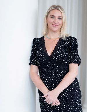 Studio portraits in a polka dot dress against a white background.