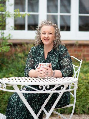 Outdoor portraits at a white metal garden table surrounded by greenery.