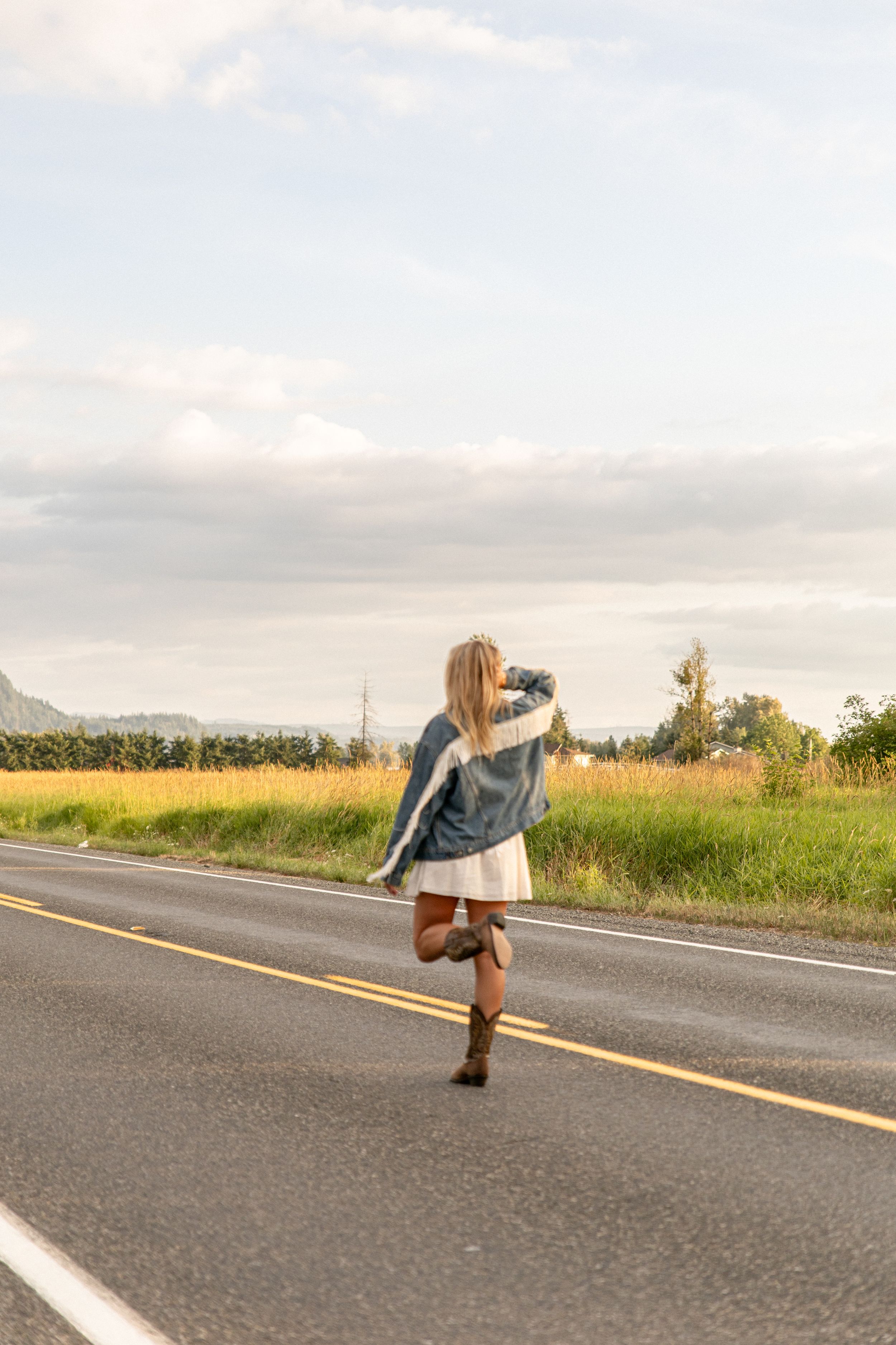 A sequence of photos showing someone doing cartwheels on an empty rural road at sunset.