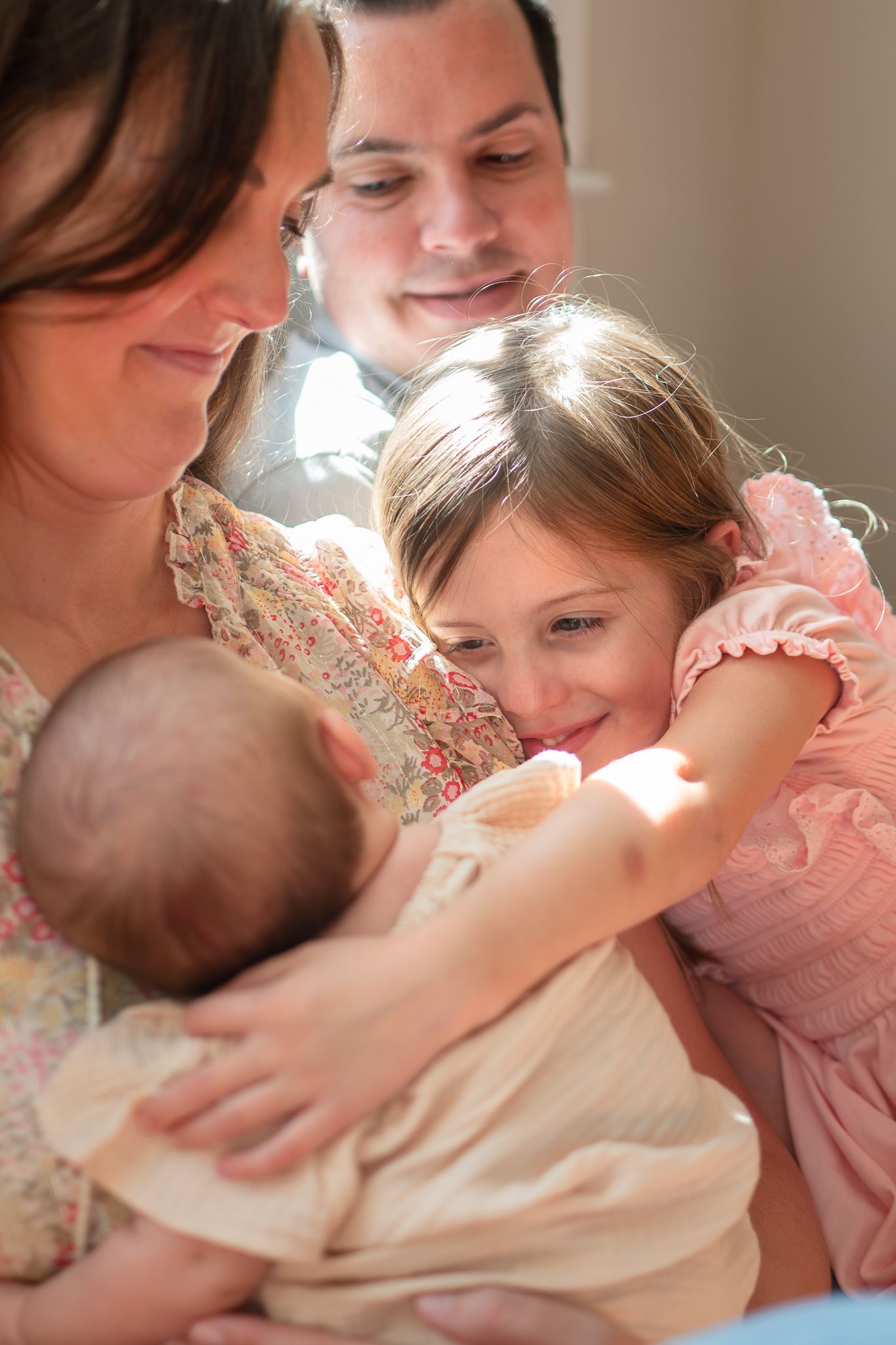 A series of tender moments showing a mother in a floral dress holding and bonding with a baby in white clothing.