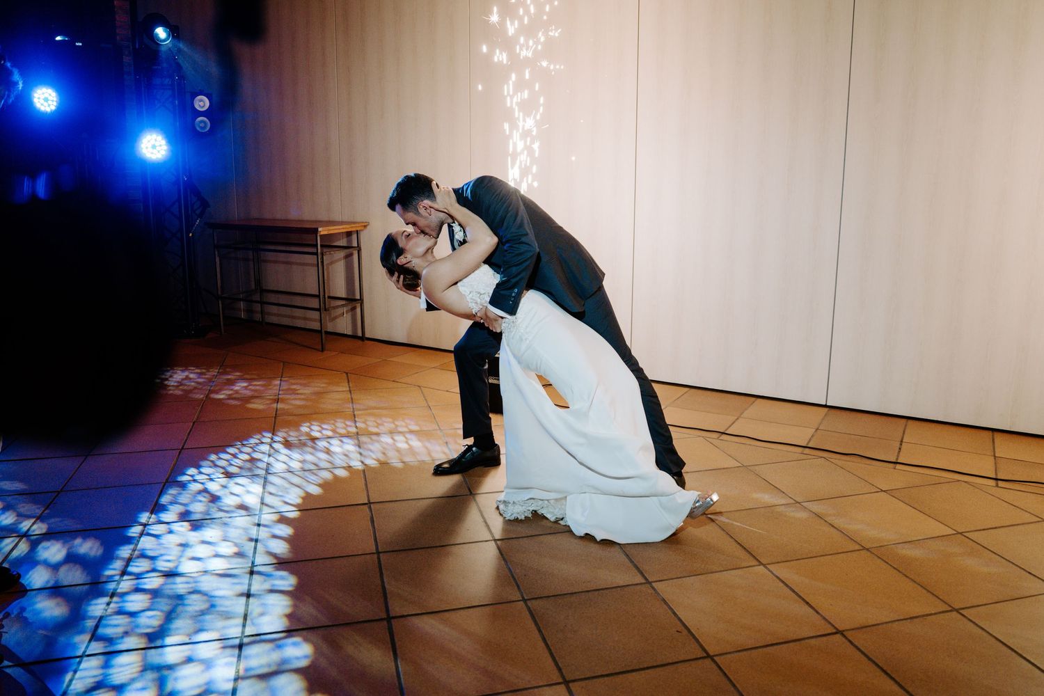 Dynamic dance moves captured on a tiled floor with blue stage lighting effects.