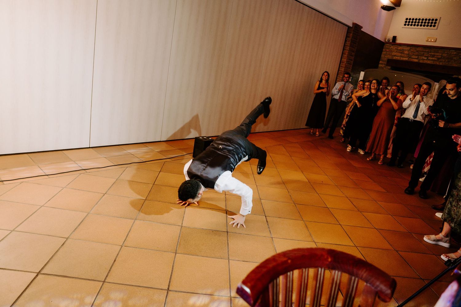 Wedding reception dance floor scene with guests celebrating under ambient lighting.
