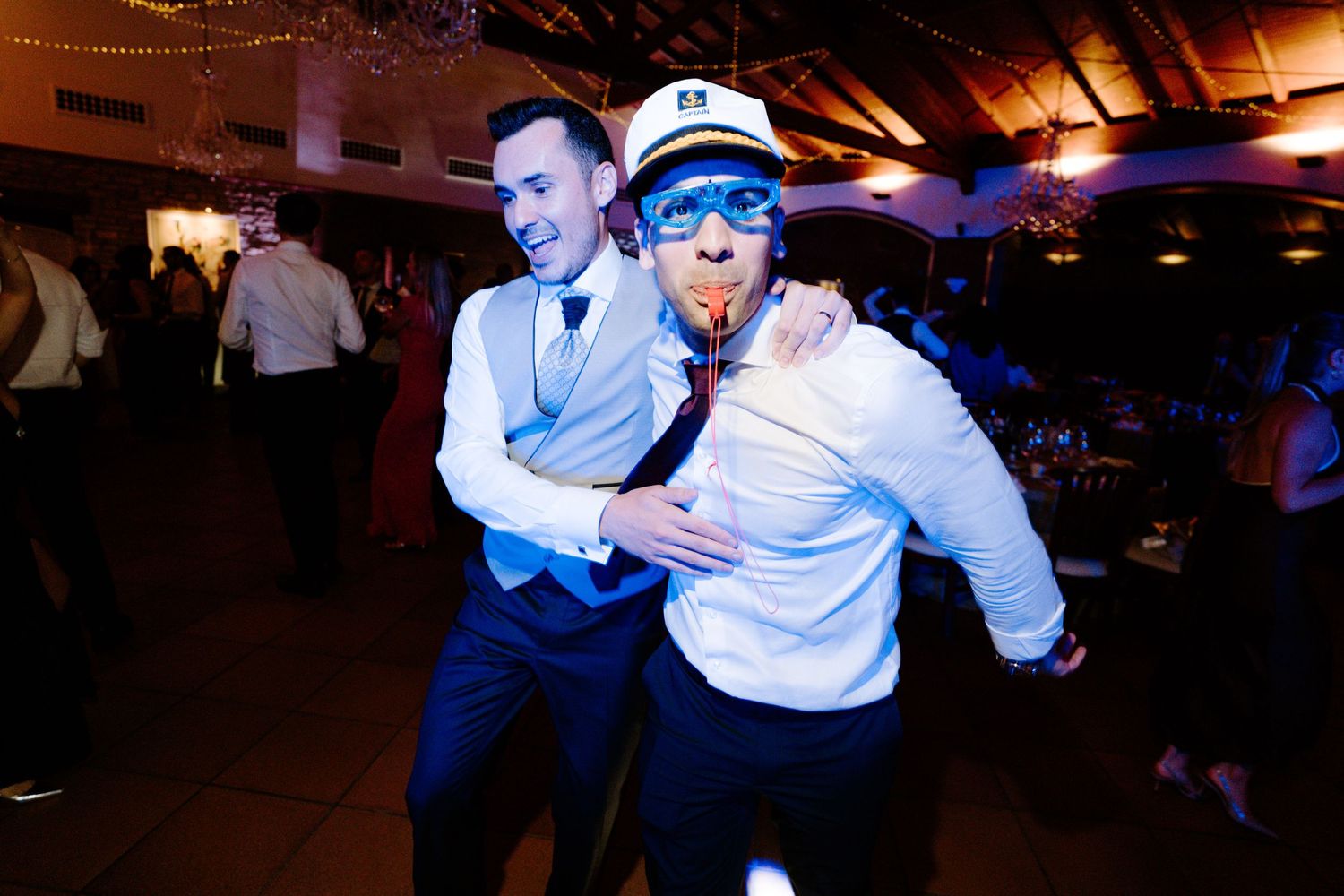 Energetic dance party moments captured in warm ambient lighting at a wedding reception.
