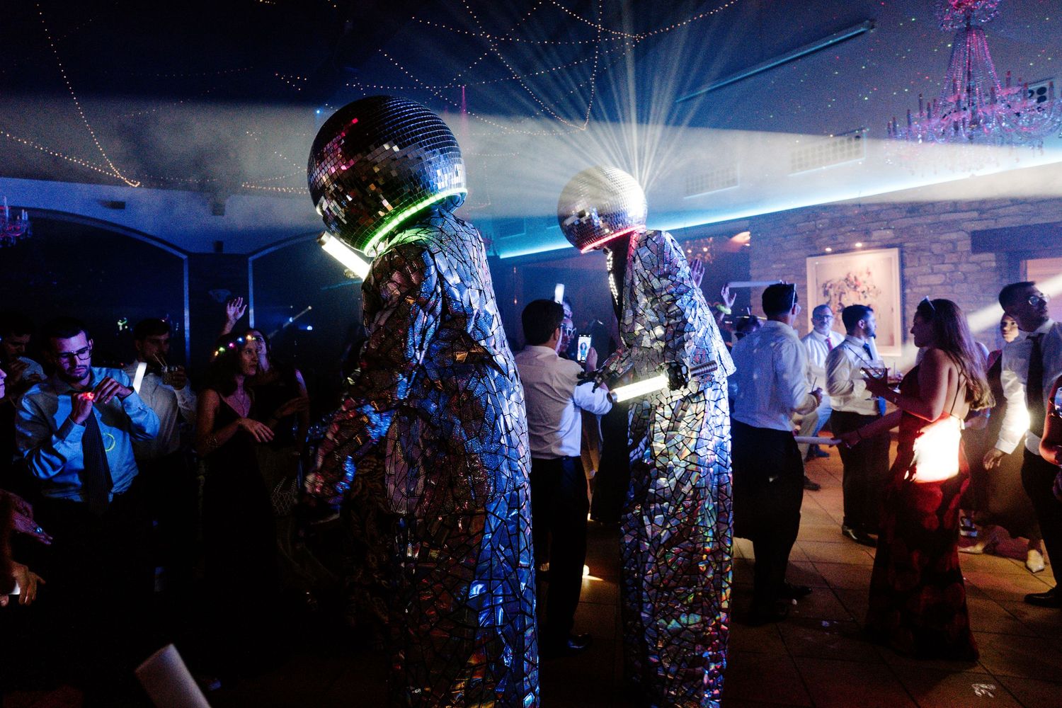 Wedding venue illuminated with dramatic lighting and disco effects creating a party atmosphere.