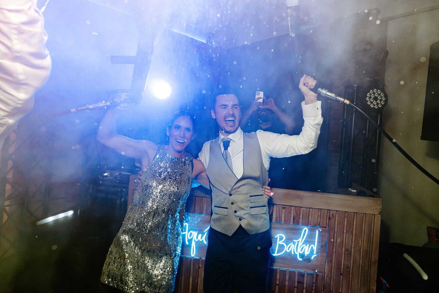 Wedding reception dance floor with dramatic spotlights and fog effects.