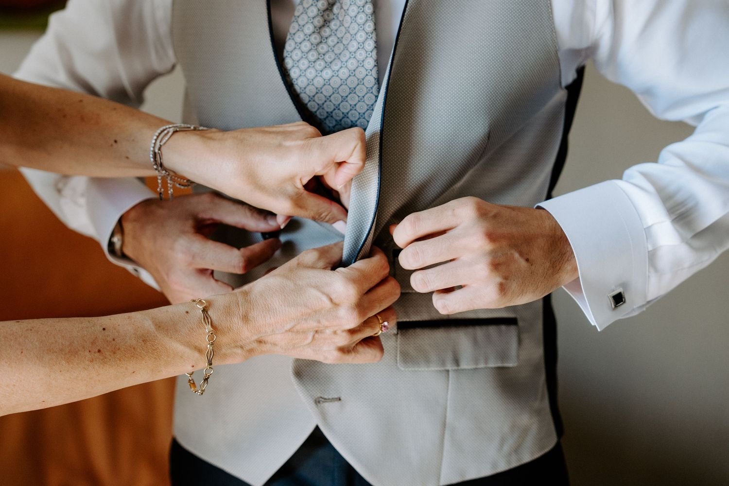 Close-up shots of hands adjusting formal wear and accessories.