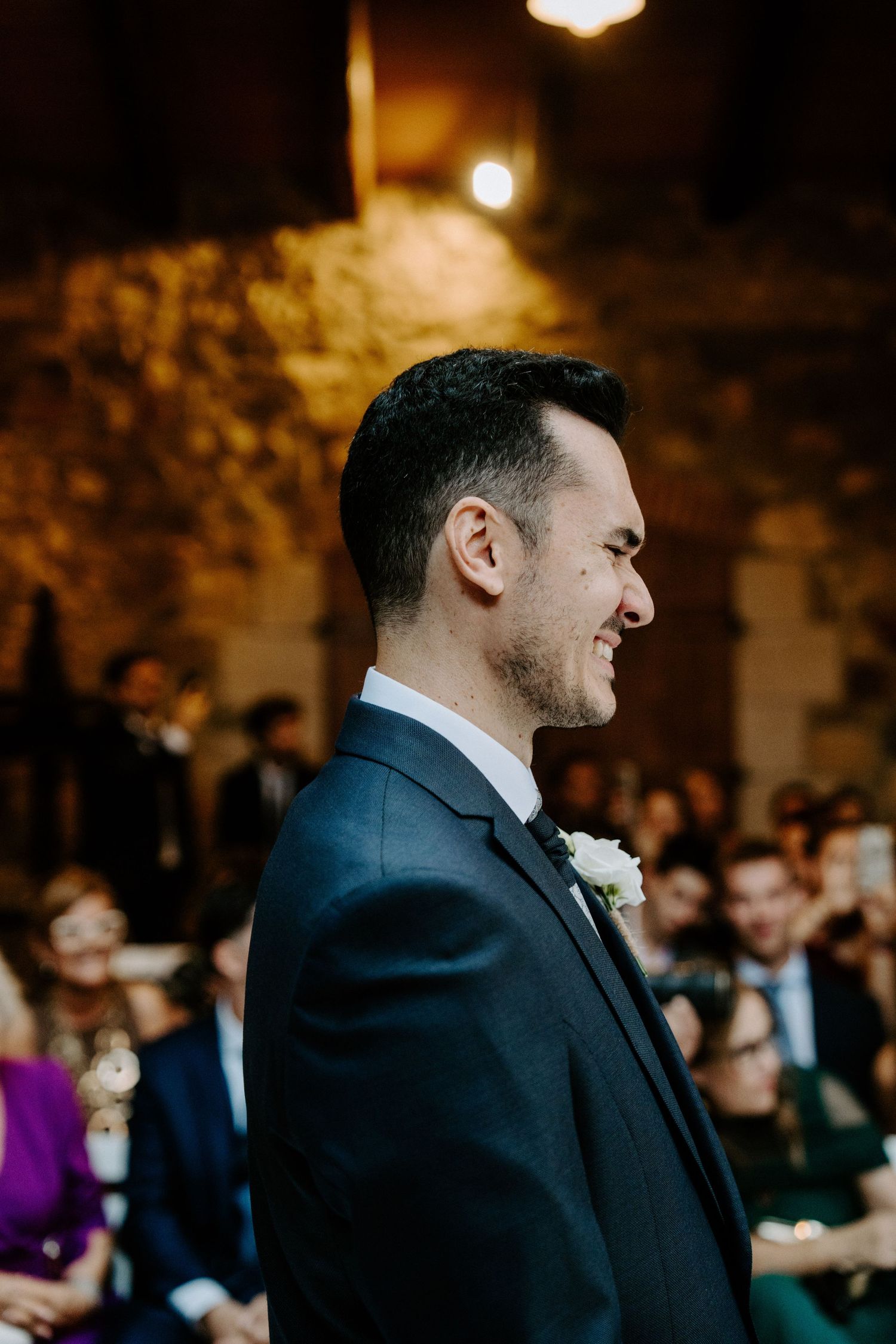 Emotional wedding ceremony moment captured in dramatic indoor lighting.