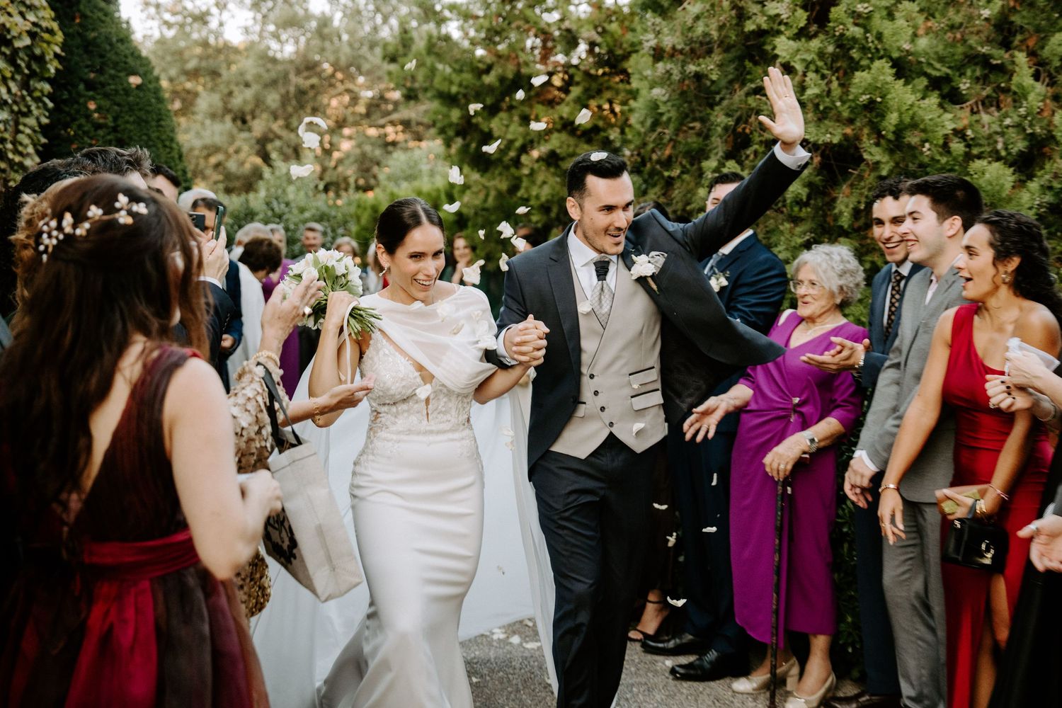 Wedding celebration with guests in formal attire gathered outdoors.