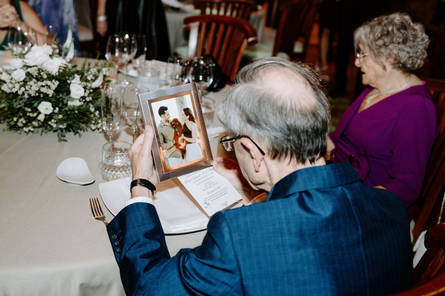 Wedding guests enjoying dinner conversation at elegantly set tables.