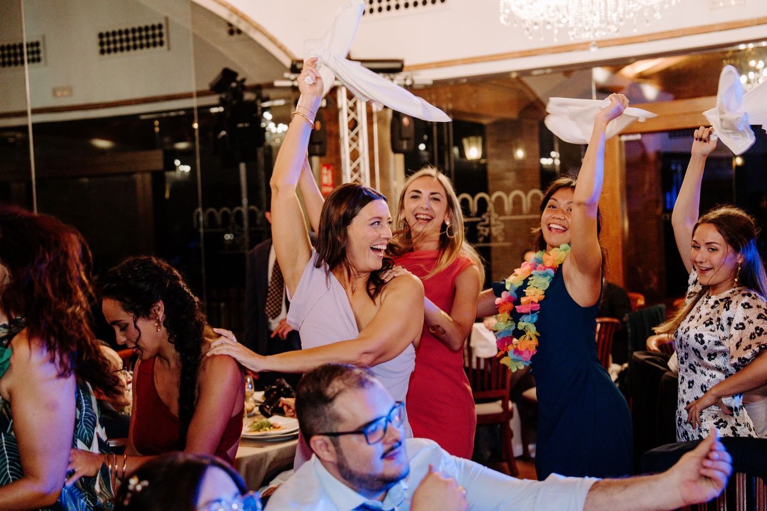 Wedding reception dance party with guests in colorful attire enjoying themselves on the dance floor.