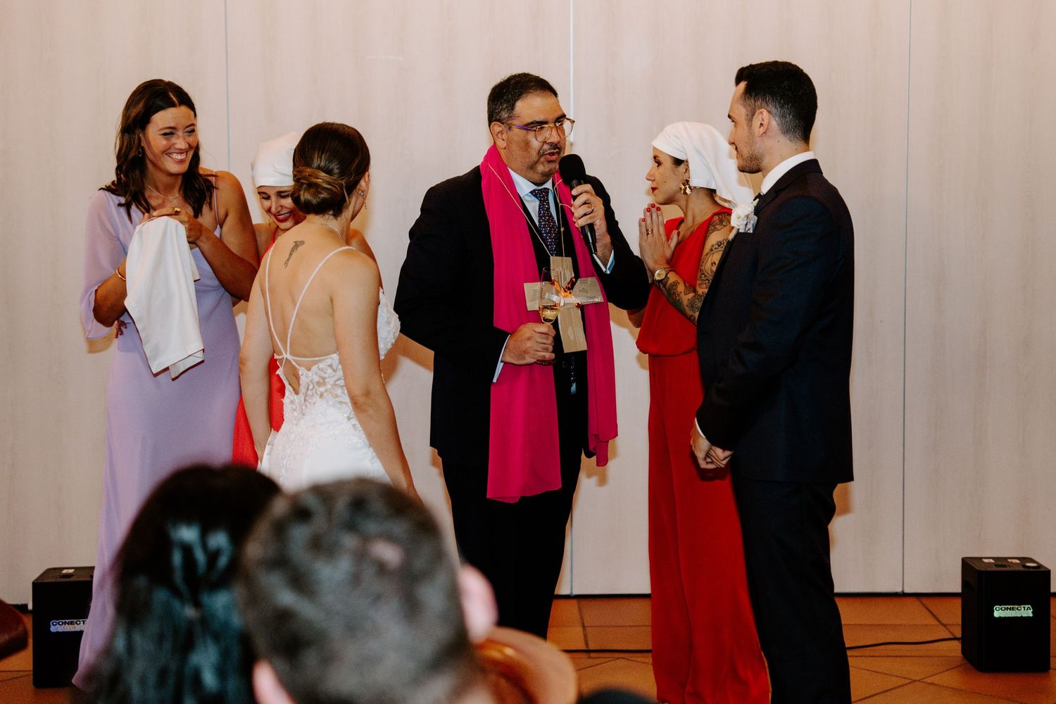 Wedding party dancing and celebrating with guests in a reception hall.