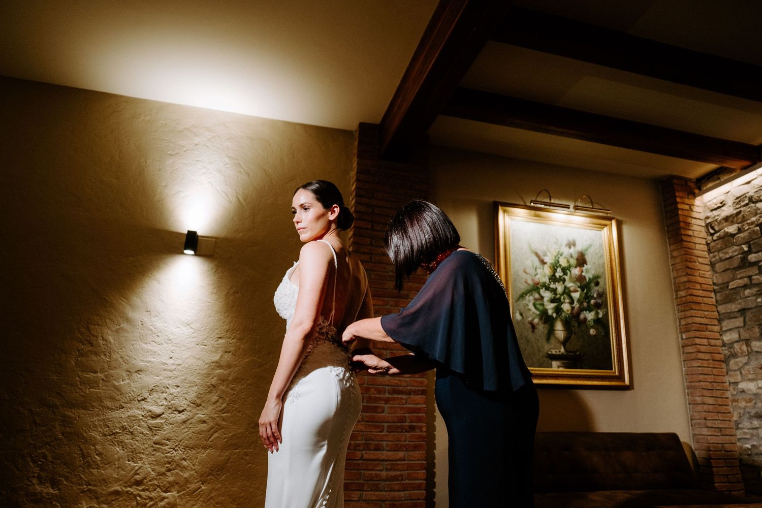 Dimly lit hallway with warm ambient lighting and exposed brick wall creating dramatic shadows.