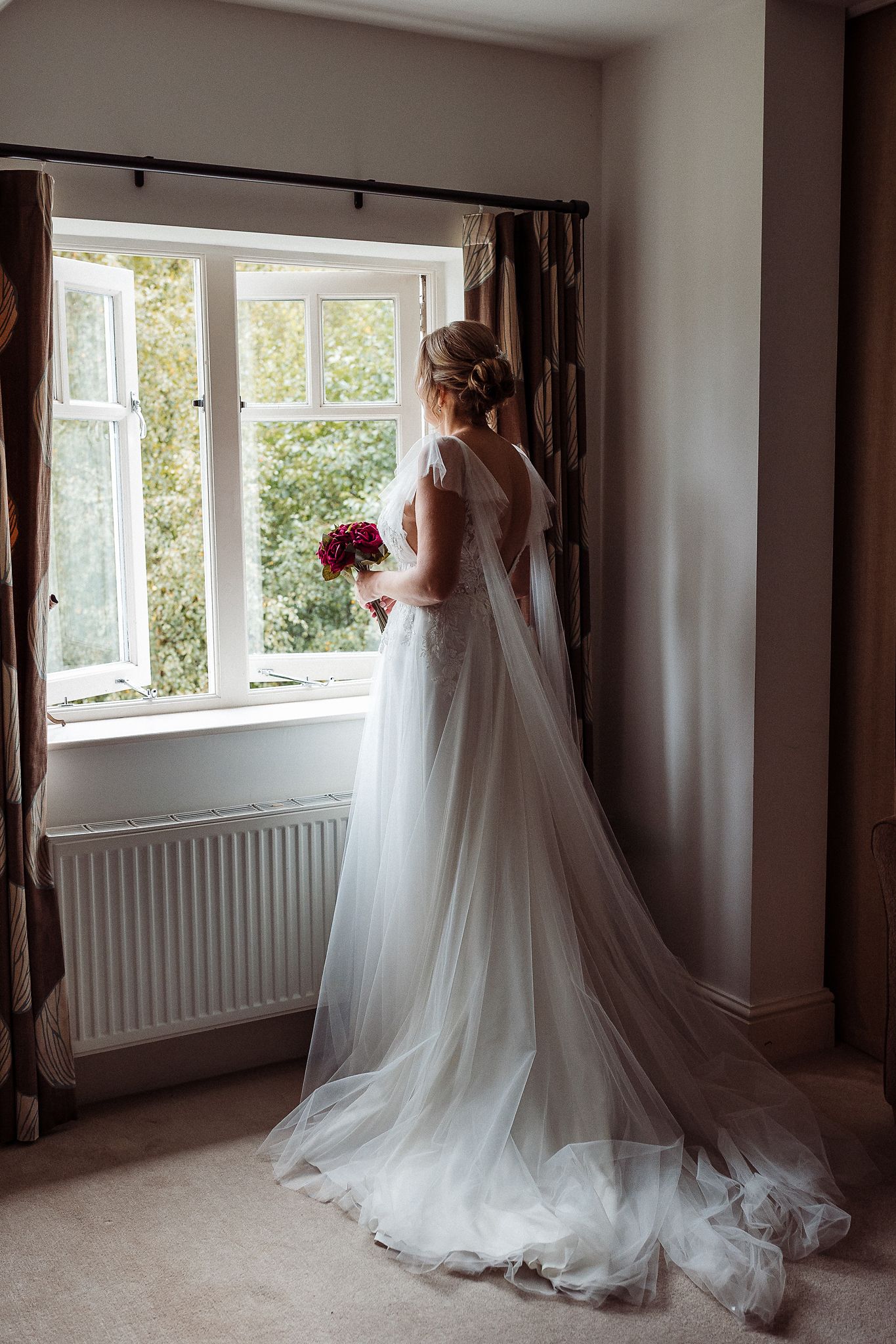 A series of wedding dress photos showing the elegant flow and train of a white gown in a sunlit room.
