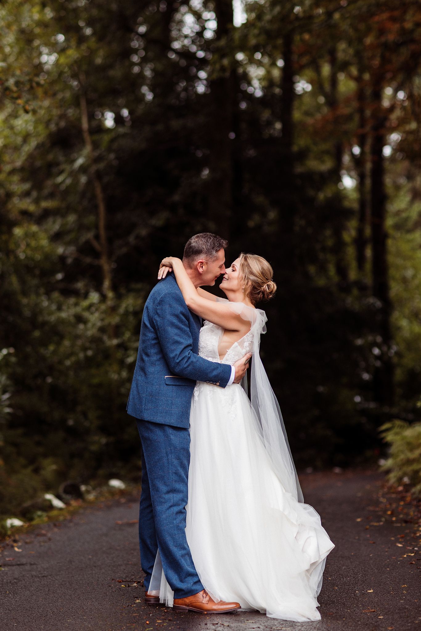 A couple in wedding attire shares romantic moments on a wooded path in a sequence of intimate photos.