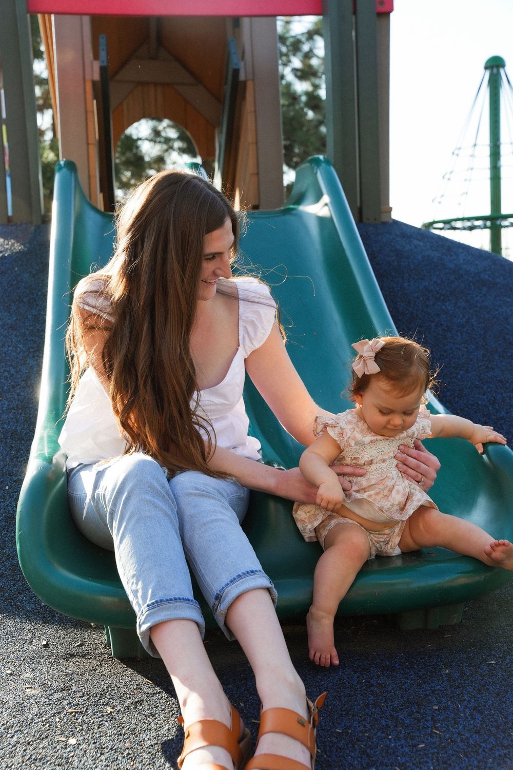 A sequence of photos showing a parent and child playing together on a blue and green playground swing.