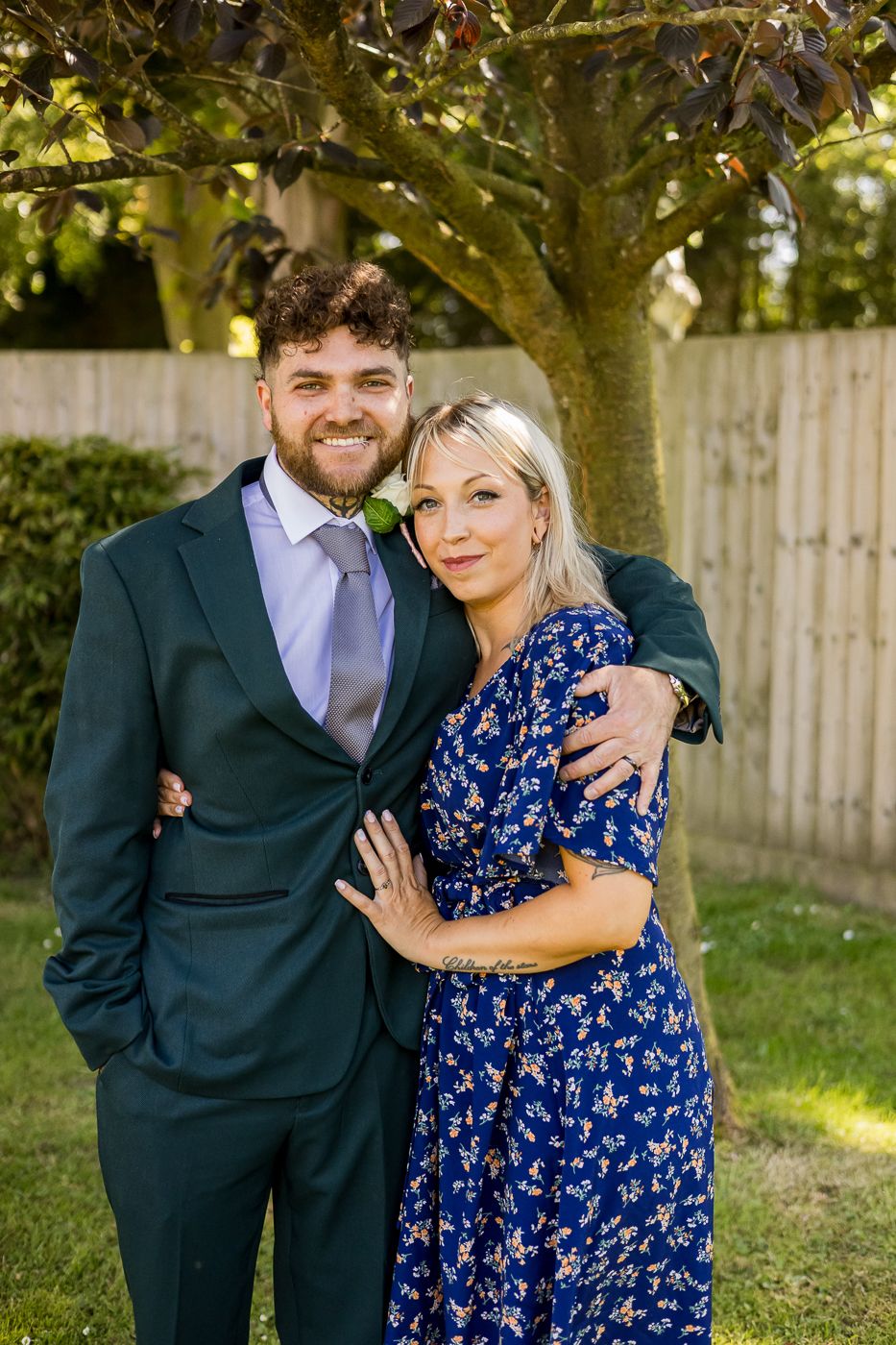 Candid moments captured between wedding party members in a garden setting.