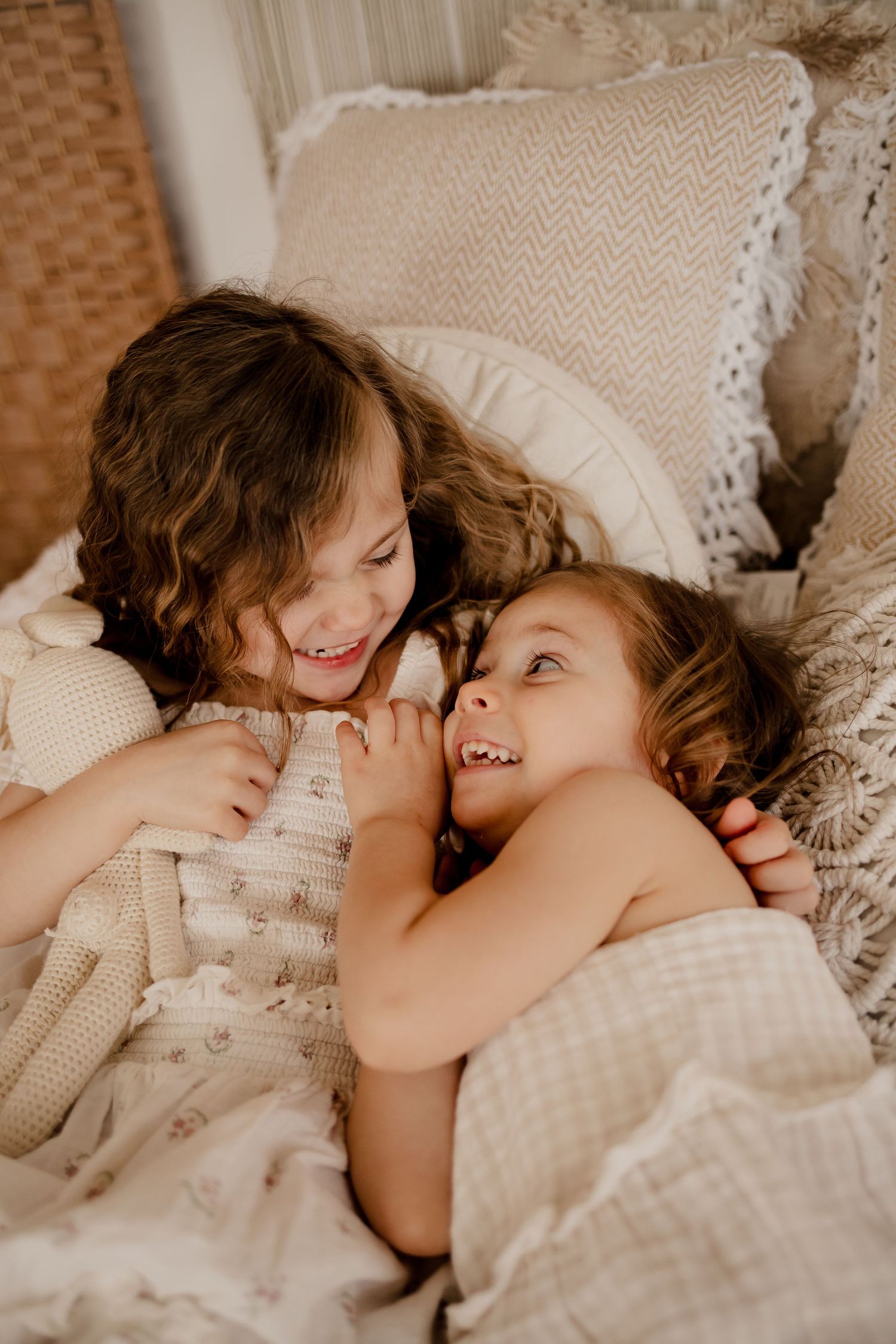 Two loving sisters sharing a sweet moment during a studio family and newborn session in St. Louis area
