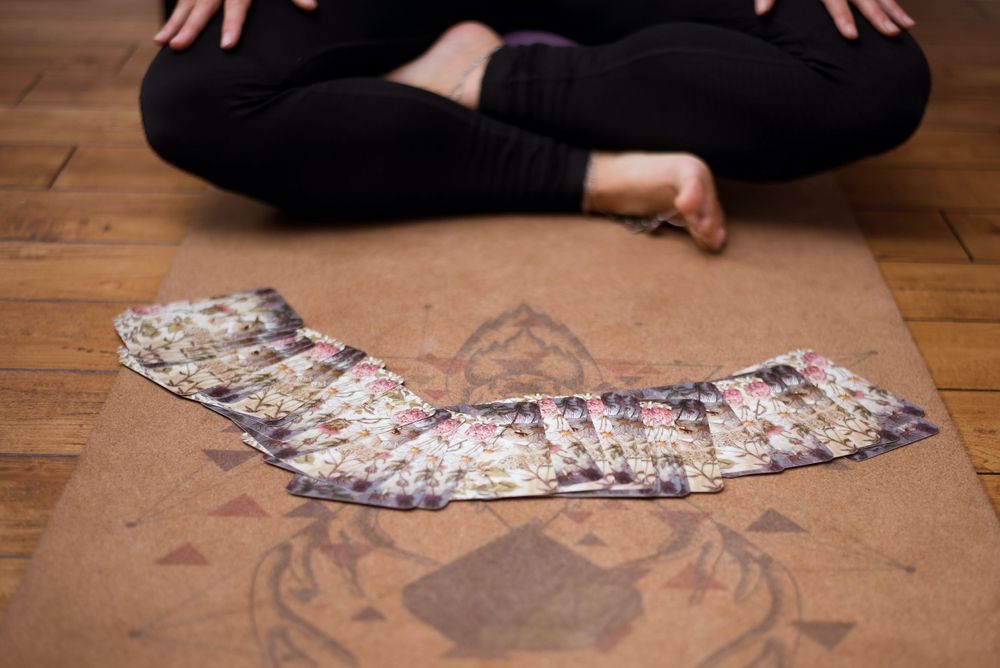 Decorative patterned cards laid out on wooden floor during meditation session.