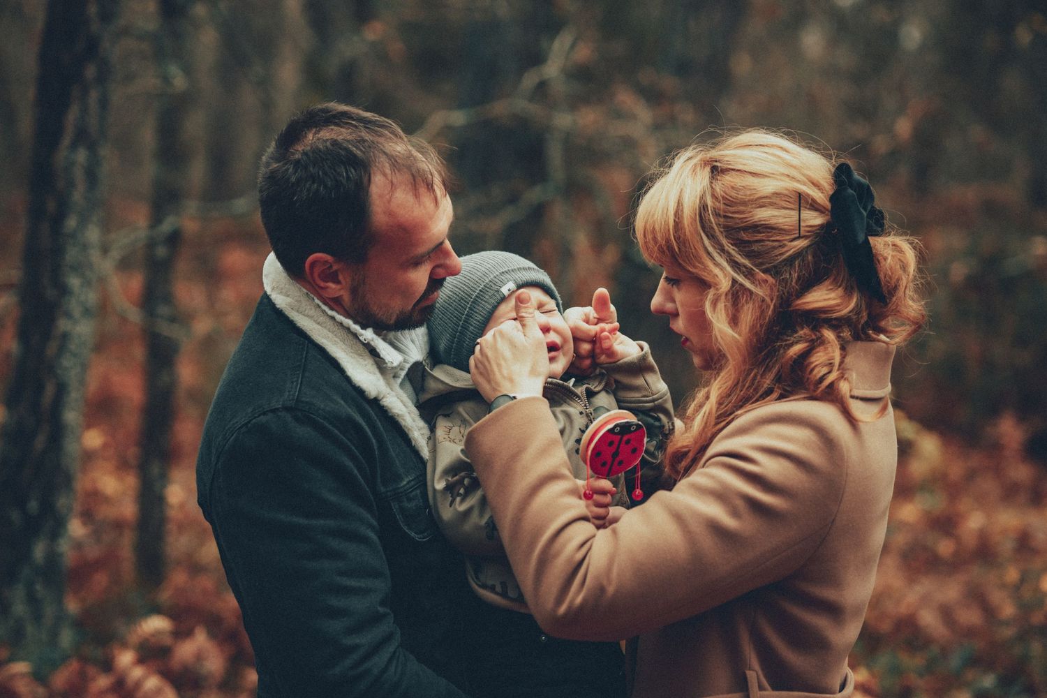 family with child surrounded autumn forest