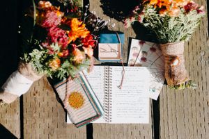 Wedding planning notebook with autumn leaves and floral decorations.