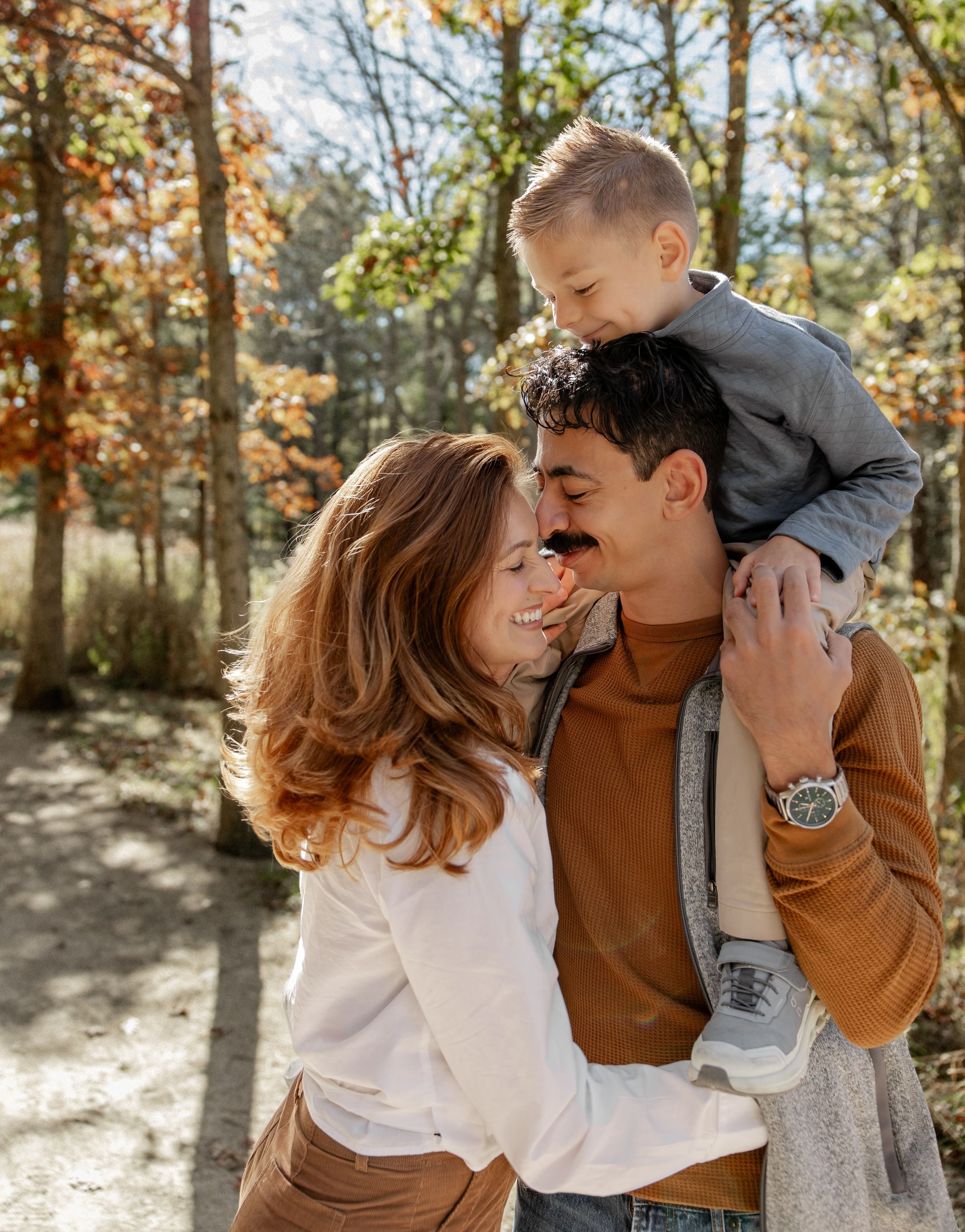Happy family sharing joyful moment in autumn forest setting.