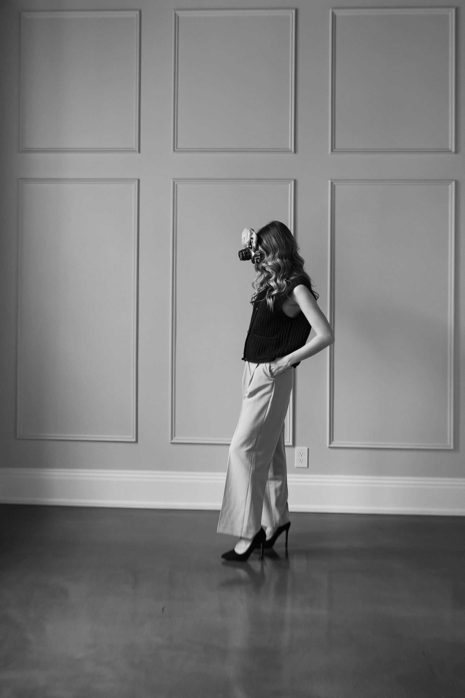 Artistic black and white photo series against white paneled wall with dramatic poses.