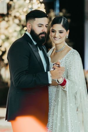 A romantic moment captured during a wedding reception with soft bokeh lights and elegant decor.