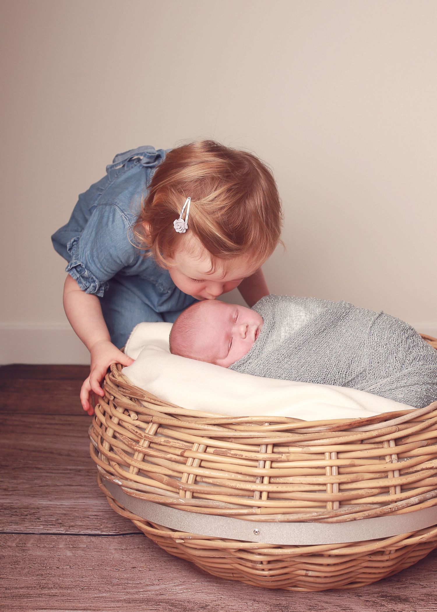 A sweet moment between a sister and her newborn brother, capturing the tenderness and love as they bond during a newborn photography session