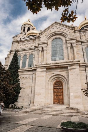 Exterior view of an ornate Orthodox church with domed roof and arched entrance featuring detailed stone architecture.