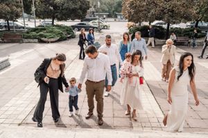 Group of people walking down stone steps outside of a church after a ceremony.